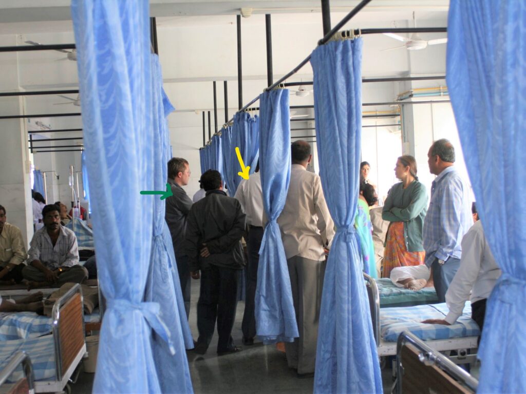 The Inspiring moments of formation of the Foundation – Dr Jaydev Panchawagh taking the German foundation members around the ward of a Hospital where he was doing his charity work. With their backs to the camera, Dr Panchawagh (Yellow arrow), Mr Sigmund Opferkuch (Green arrow)